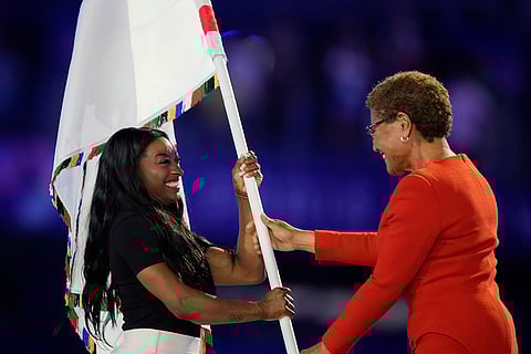 Los Angeles Mayor Karen Bass hands the Olympic flag to United States' gymnast Simone Biles during the 2024 Summer Olympics closing ceremony